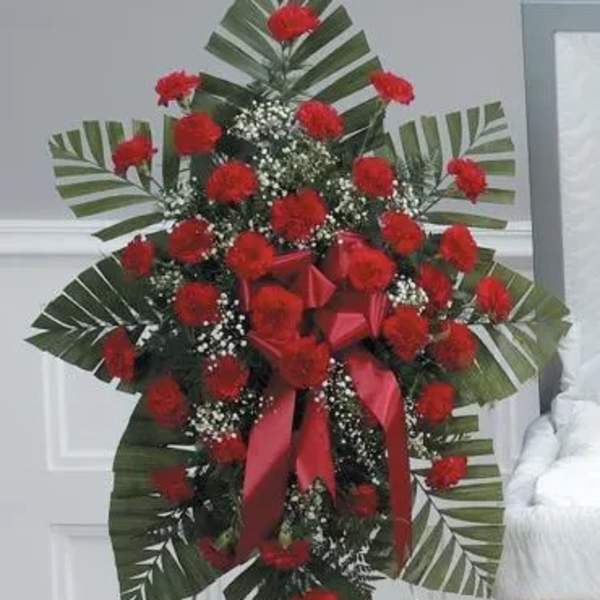 Standing floral spray with red carnations and ribbon accents