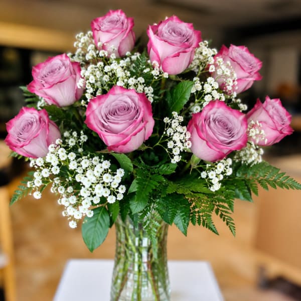 Pink roses and white baby's breath in a clear glass vase