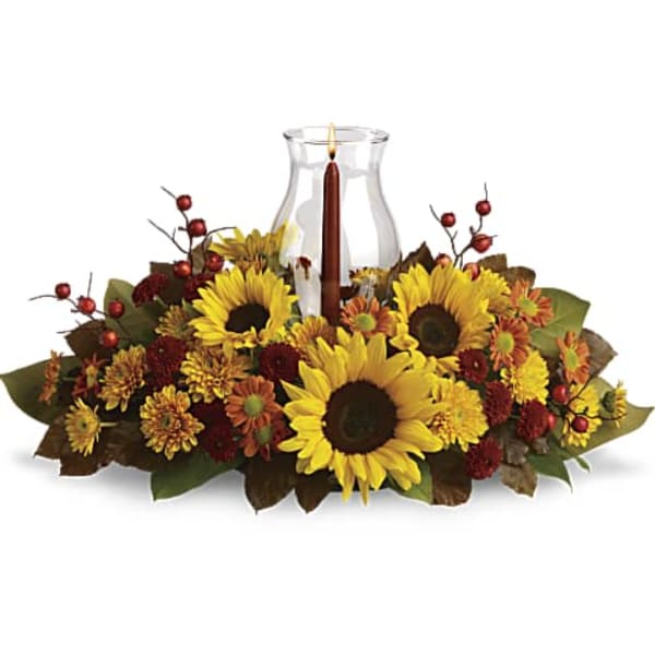 Sunflower centerpiece around a glass hurricane vase with a candle