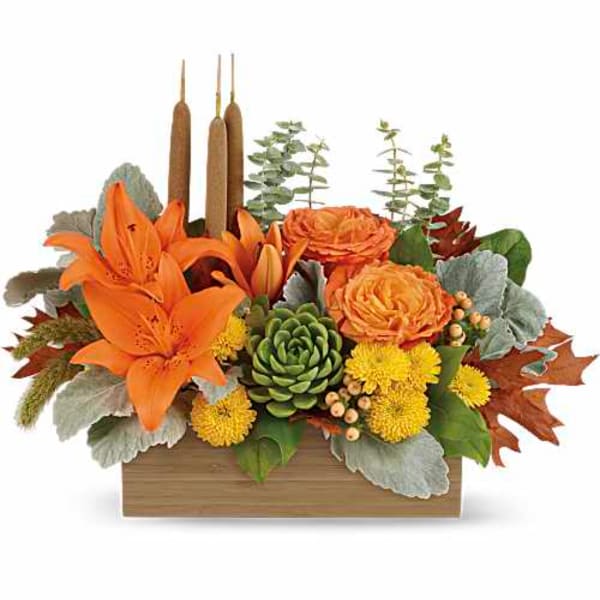 Orange lilies and roses in a wooden box with candles and succulents