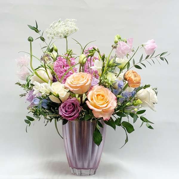 Mixed pastel bouquet in a purple glass vase
