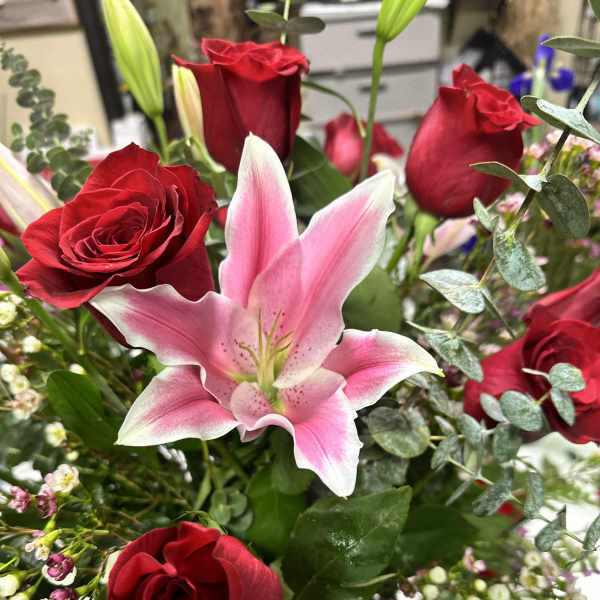 Bouquet of red roses and a pink lily