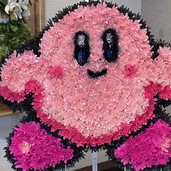 Pink floral character arrangement with a smiling face and black outline