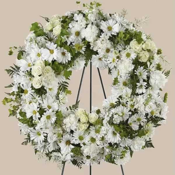 White floral wreath on a black stand