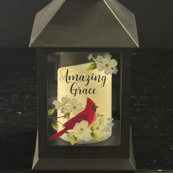 Black lantern with a cardinal and floral design reading "Amazing Grace"