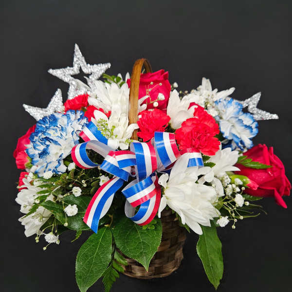 Basket of red, white, and blue flowers with star decorations and ribbon