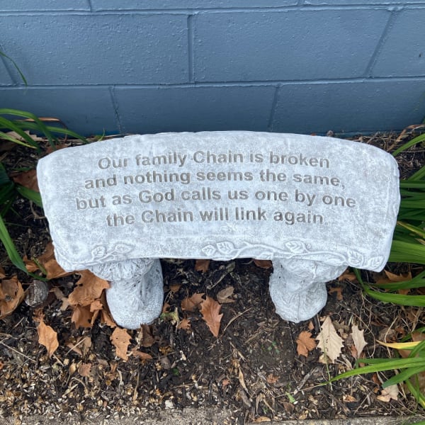 Stone memorial bench with an engraved sympathy message outdoors