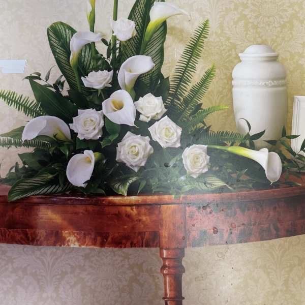 White calla lilies and roses arranged on a table