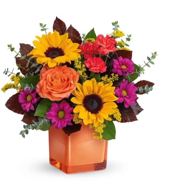 Colorful bouquet with sunflowers, roses, and daisies in an orange vase
