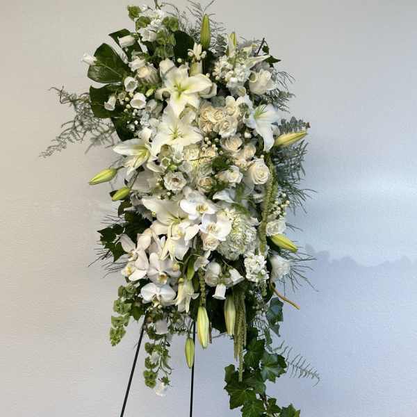 Tall white floral standing spray on a black easel