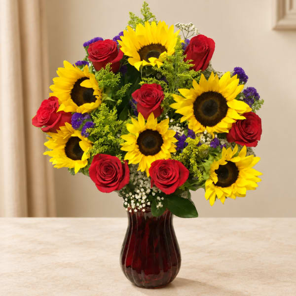 Bouquet of sunflowers and red roses in a red glass vase