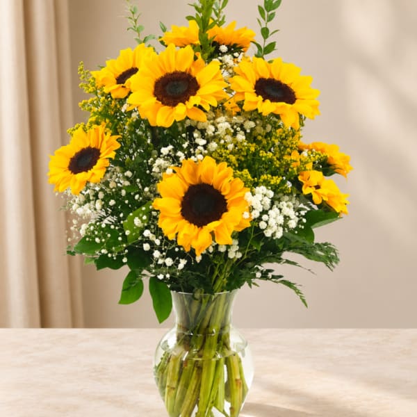Sunflower bouquet in a clear glass vase with white filler flowers