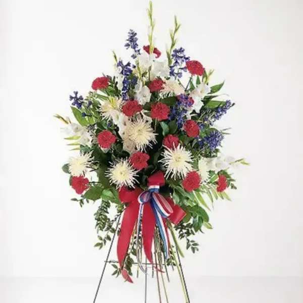 Standing floral spray with red, white, and blue flowers on an easel