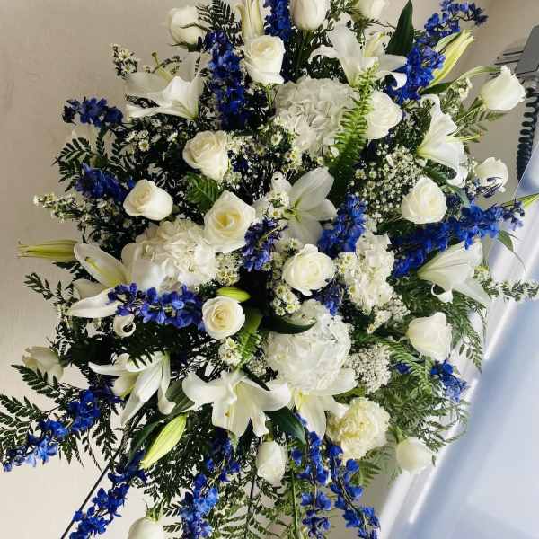 Large white and blue floral standing spray with lilies and roses