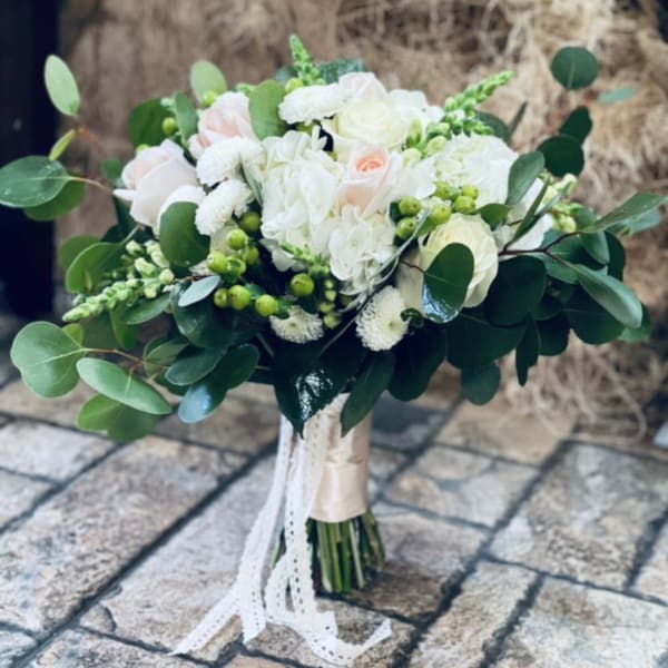 White and blush bouquet with roses and hydrangea, tied with ribbon