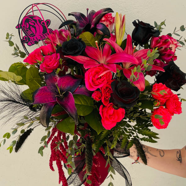 Bouquet of hot pink and black flowers with lilies and roses