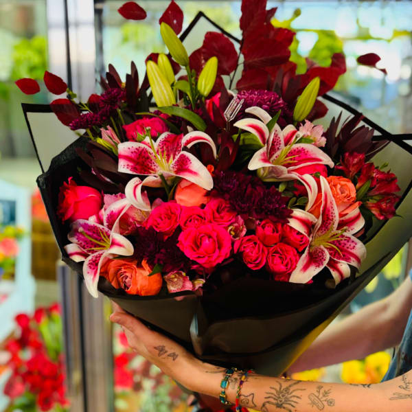 Bouquet of pink roses and lilies wrapped in black paper