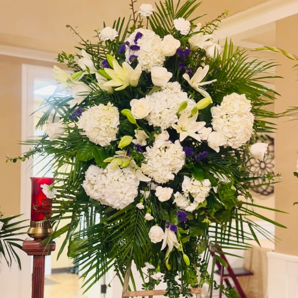 Large white floral standing spray with lilies and roses