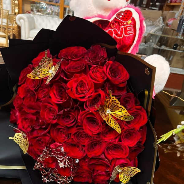 Bouquet of red roses wrapped in black paper with gold butterfly accents