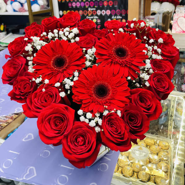 Heart-shaped bouquet of red roses and gerbera daisies with baby's breath