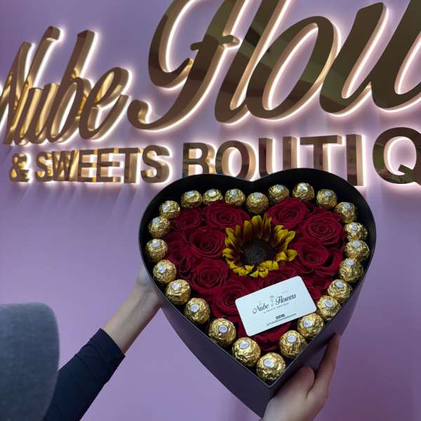 Heart-shaped box of red roses with a sunflower and gold chocolates