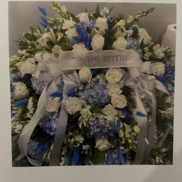 Large white and blue floral spray with a "Loving Mother" ribbon