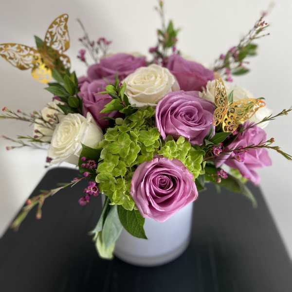 Pink and white roses arranged in a white vase