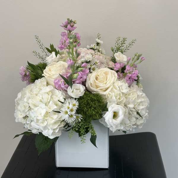 White and pink floral arrangement in a square vase