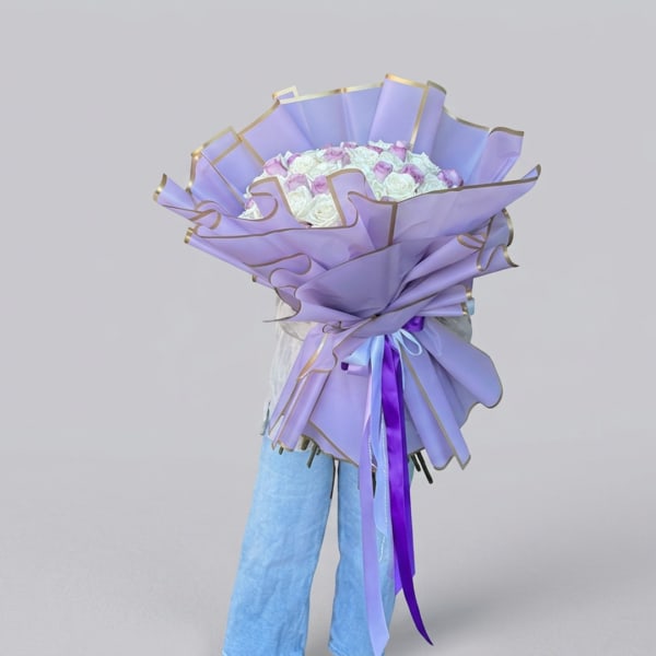 Lavender-wrapped bouquet of white and pink roses with ribbon