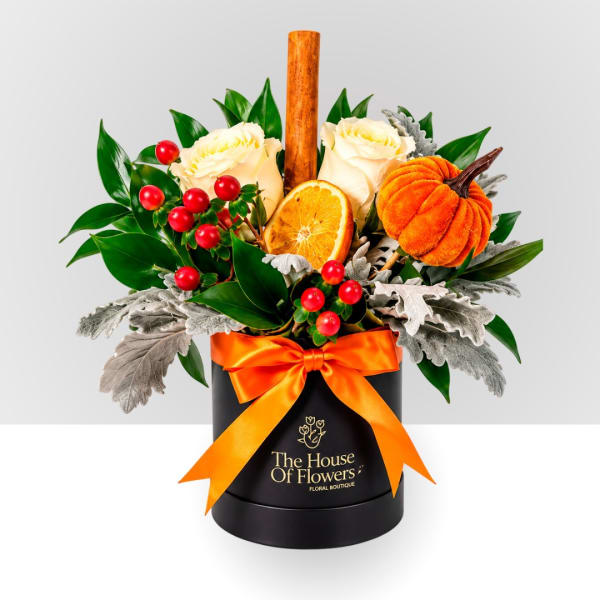 White roses in a black box with an orange ribbon and pumpkin accent