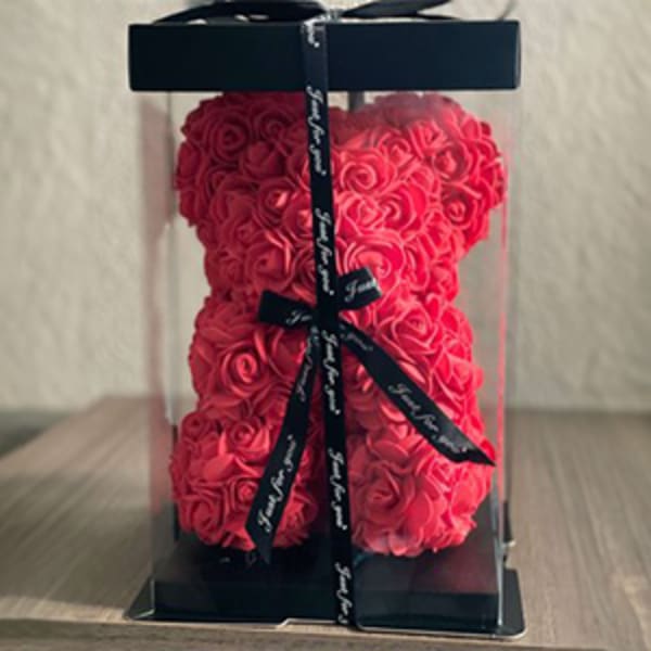 Pink rose teddy bear in a clear display box with a black ribbon