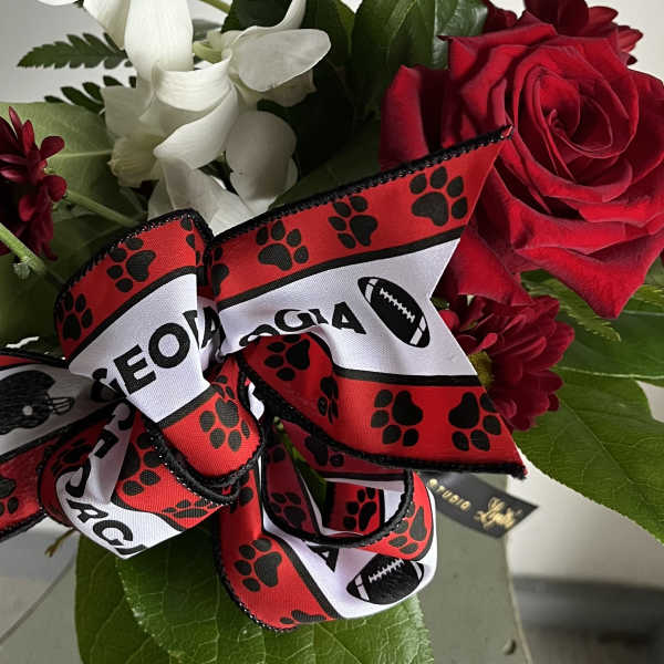 Red roses and white orchids with a football-themed ribbon