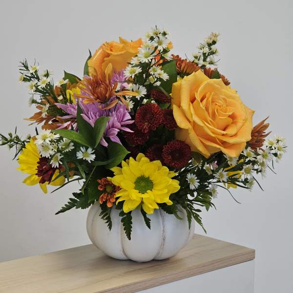 Mixed bouquet of roses and chrysanthemums in a white pumpkin vase