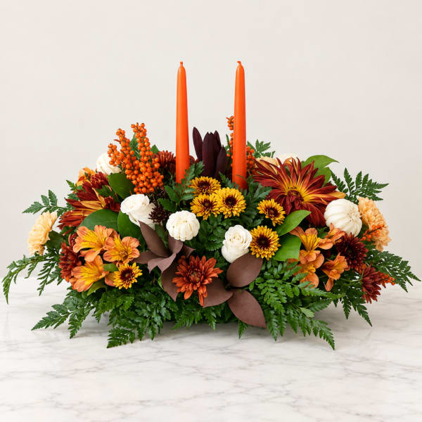 Autumn floral centerpiece with orange candles and mixed blooms