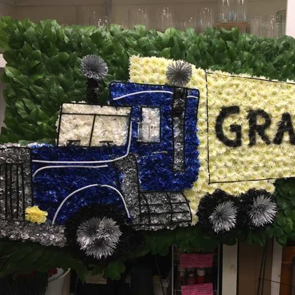 Floral truck display with a large yellow sign reading GRAMPS