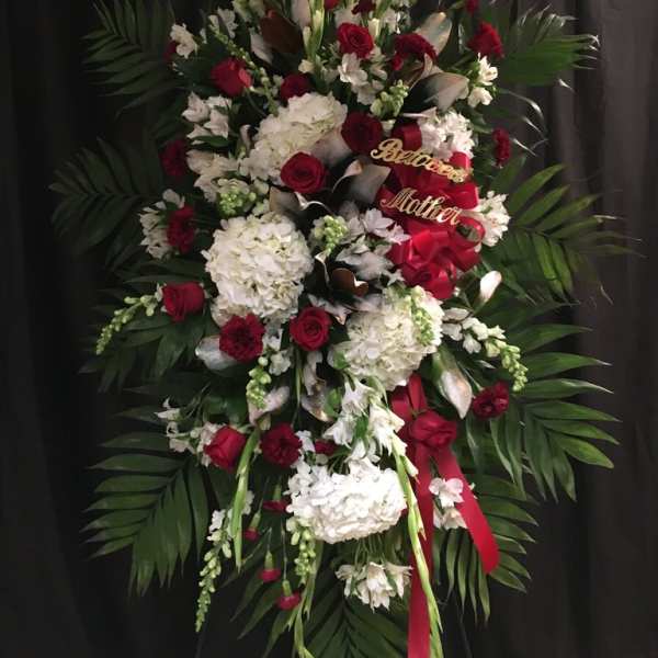 Large standing floral spray with red and white flowers and a red ribbon