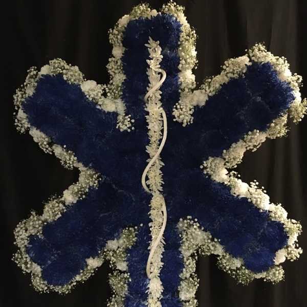 Blue and white floral standing spray shaped like a cross