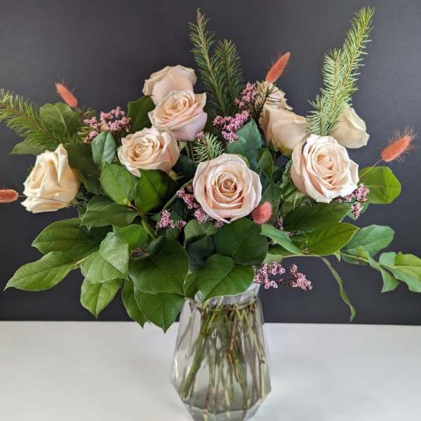 Bouquet of pale blush roses in a clear glass vase