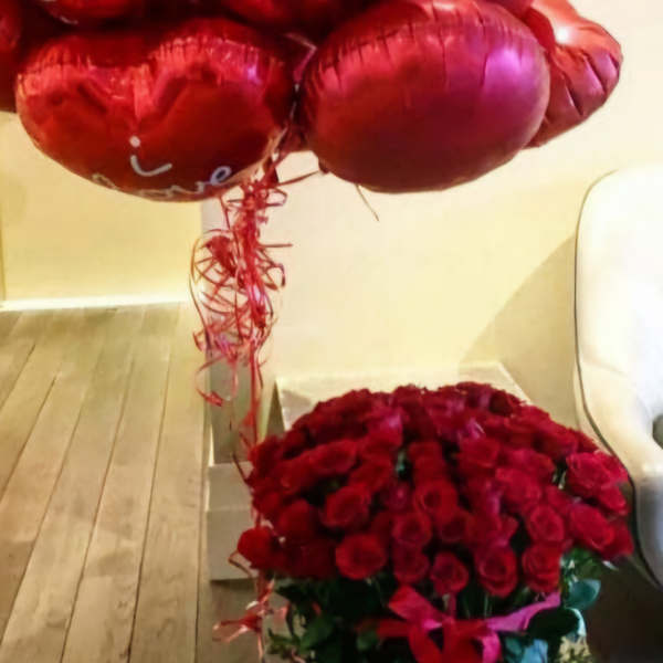 Basket of red roses with red heart balloons above