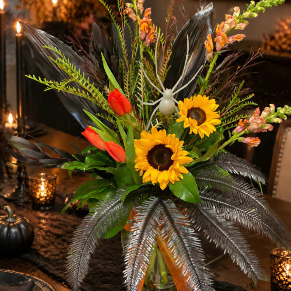 Tropical bouquet with sunflowers, red tulips, and pink snapdragons in a glass vase
