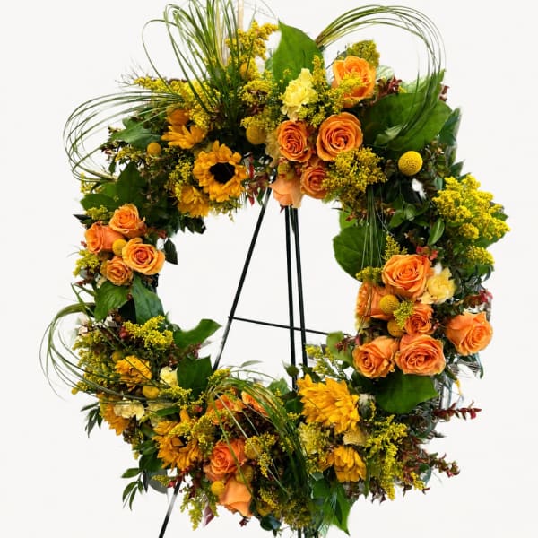 Orange and yellow floral wreath on a stand