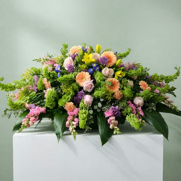 Large mixed floral arrangement with pink, peach, yellow, and purple blooms