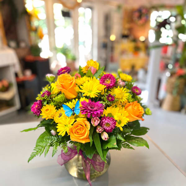 Bright mixed bouquet of yellow and orange flowers in a glass vase