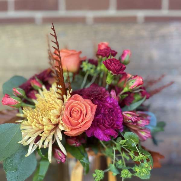 Bouquet of coral roses, yellow chrysanthemums, and magenta blooms