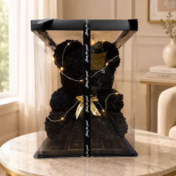 Black rose teddy bear in a clear gift box with ribbon and lights