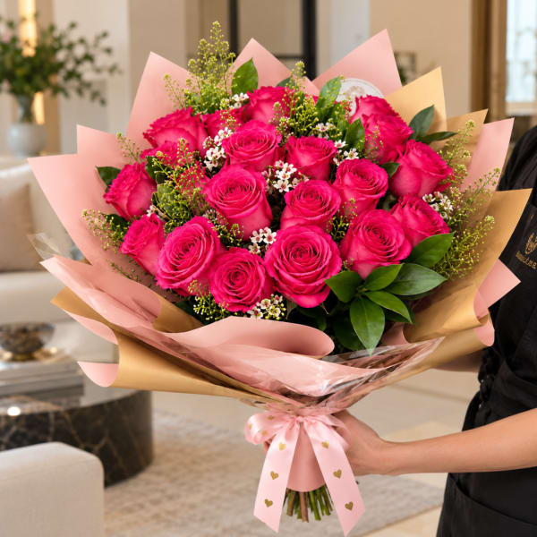 Bouquet of bright pink roses wrapped in pink and gold paper