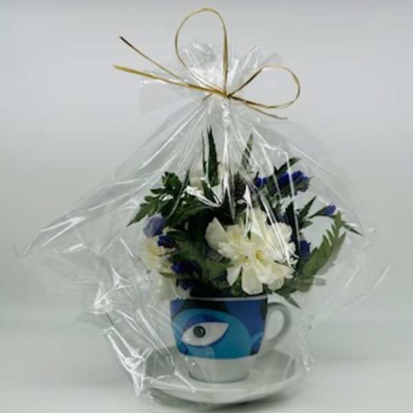 Wrapped flower arrangement in a blue mug with an eye design