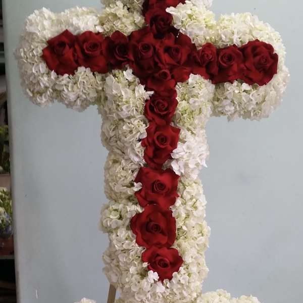 Large floral cross made of white flowers with red roses