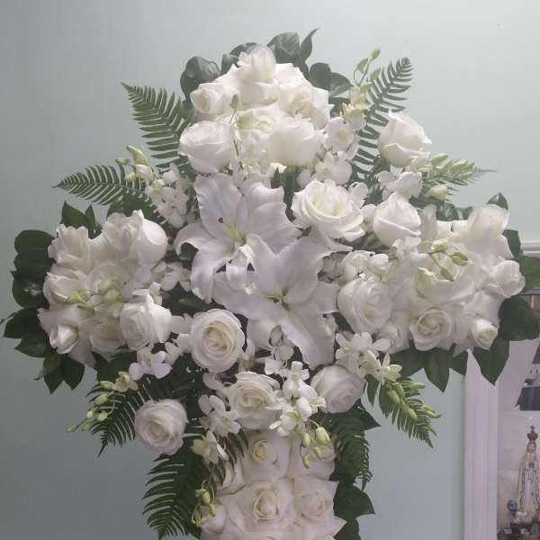 White floral cross arrangement with roses and lilies