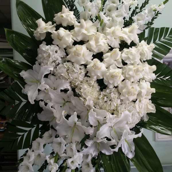 Large white funeral spray with lilies and roses
